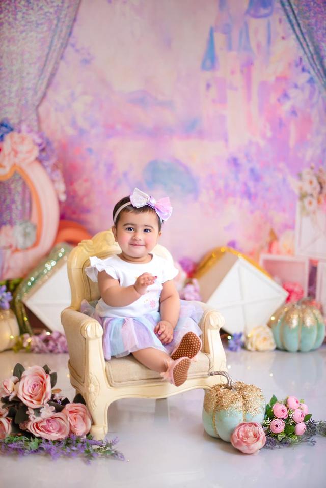Mahveen smiling on a little princess chair